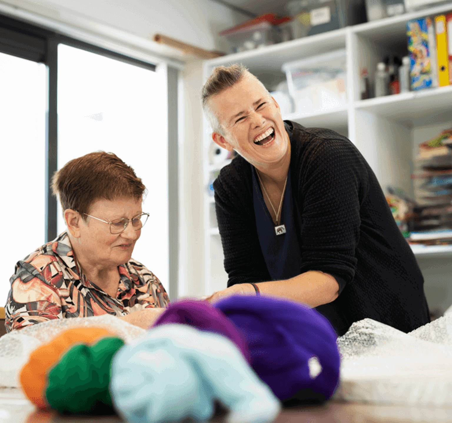 Zorgmedewerker en cliënt lachend op de foto