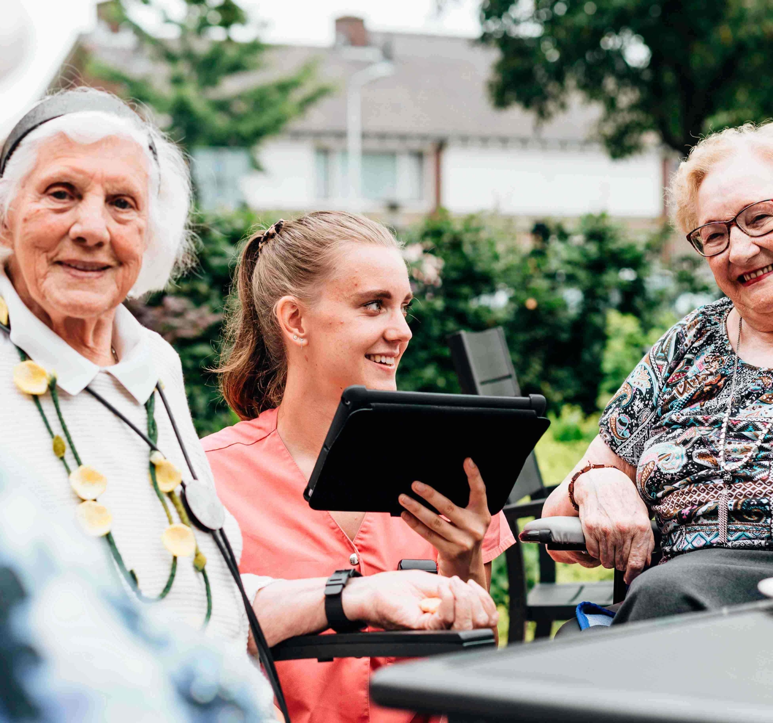 Zorgmedewerker met vrolijke cliënten in de vvt